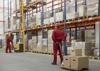 Men move boxes around a large warehouse