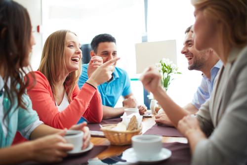 Happy employees sit around a table to collaborate at work