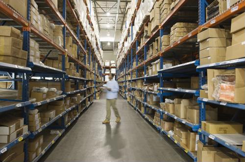 A worker walks through a warehouse of boxes